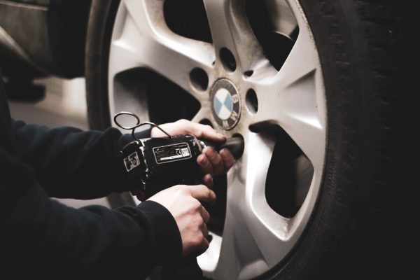 mechanic puts new tire on for roadside assistance